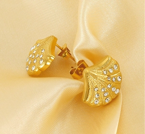 Macro shot of 18K gold plated shell earrings with sparkling crystal pavé inlay