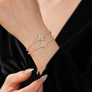 Detailed view of shimmering zircon flower bracelets in gold and silver on model wrist