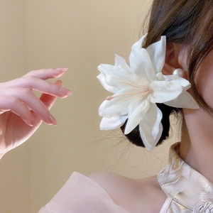 Detail showing high-quality white silk lily hair clip on model for holiday style