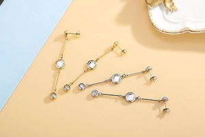 Detail of long tassel earrings in gold and silver with sparkling round zircon crystals