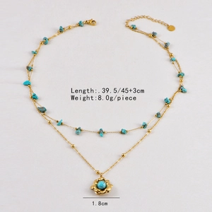 Dettaglio di una collana dorata a due strati con pietre turchesi e pendente floreale