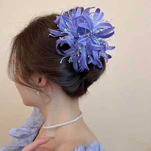 Détail d'une grande pince à cheveux en tissu violet avec pétales réalistes et étamines