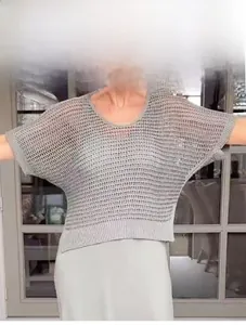 Dettaglio di un top grigio in maglia traforata a maniche corte con trama traspirante