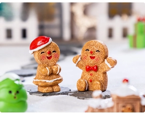 Miniature resin gingerbread man figurines in a snowy Christmas scene micro landscape