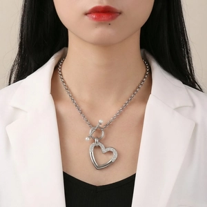 Détail du collier pendentif coeur argenté avec strass et fermoir en T orné de perles