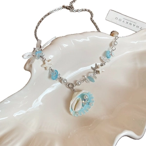 Starfish pearl necklace with blue crystal and shell pendant on a white background