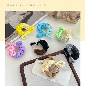 Close-up of assorted colorful braided hair ties arranged on a stylish wooden tray