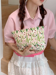 Canvas tulip floral cosmetic bag for travel shown held in hand by a model