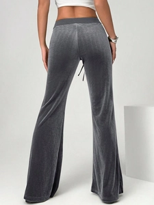 Detail view of high-waist velvet flared trousers with smooth texture and back waist tie