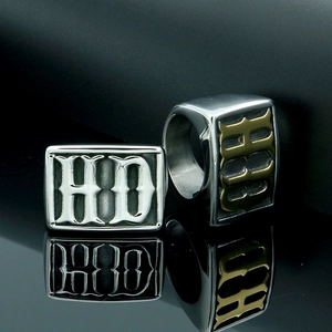 Close-up of gothic HD lettering on a chunky silver and gold tone punk style ring