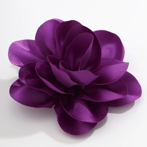 Detail of purple layered fabric flower brooch with matte and satin petal textures