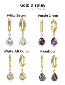 Detailed view of four pairs of gold hoop earrings with colorful pear-cut zircon pendants