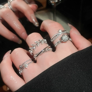 Close-up of silver ring set with zircon stars and pearls showing multi-finger layering style