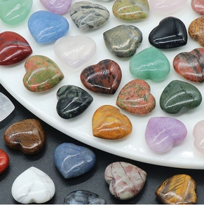 Macro shot of assorted colorful 20mm heart-shaped natural crystal stones on a white plate