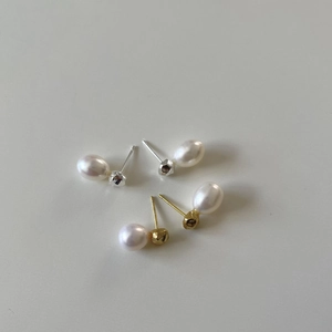 925 sterling silver pearl stud earrings with gold and silver bases on a light gray background