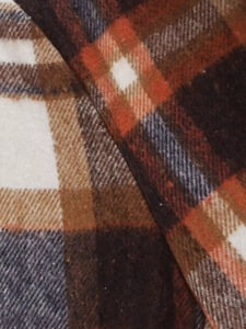 Close-up detail of soft plaid wool fabric in orange, brown and navy blue check pattern