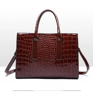 Detail view of the back of a dark wine red faux crocodile leather tote with handles