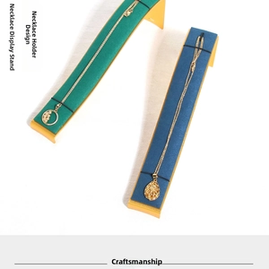 Close-up of curved microfiber necklace display stands in dark green and royal blue