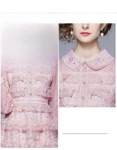 Détails du col en dentelle rose avec bords festonnés et broderies sur la robe chic