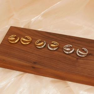 Set of minimalist 316 stainless steel hoop clip earrings in gold and silver on wood