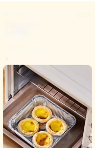 Detail of square aluminum foil tray with egg tarts baking inside an oven