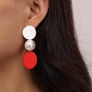 Asymmetric red and white geometric drop earrings with pearls on model closeup