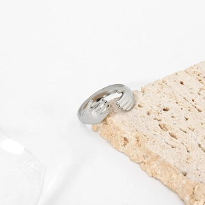 Vue détaillée d'une bague mains qui s'enlacent en argent sur pierre naturelle