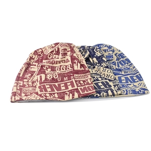 Close-up of vintage newspaper print beanies with red and blue letter patterns