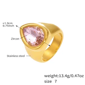 Détail macro d'une bague chunky dorée à l'or 18 carats avec zircon rose goutte