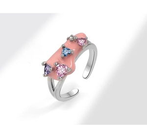Macro shot of silver open ring with pink enamel and colorful heart zircon stones