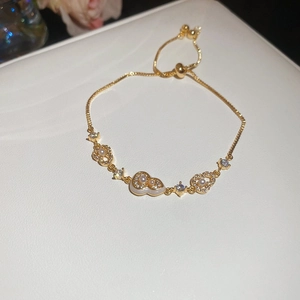 Macro detail of 18k gold plated gourd charm bracelet with pearls and sparkling zircon