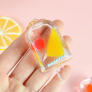 Cute popsicle keychain with yellow ice cream model and gold bead chain on pink background