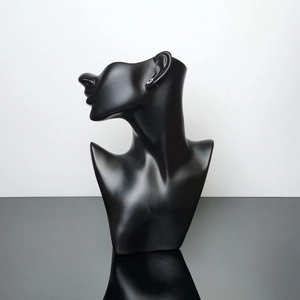 Detail view of matte black mannequin head display for elegant earring presentation