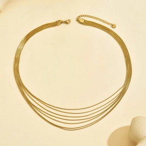 Dettaglio collana a catena a serpente dorata a più strati con chiusura a moschettone e catena