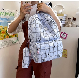 Detail of light blue plaid backpack with cartoon print and matching small pouch charm