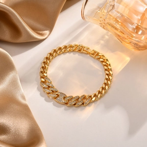 Detailaufnahme eines vergoldeten Gliederarmbands mit glänzenden Zirkonia-Steinen