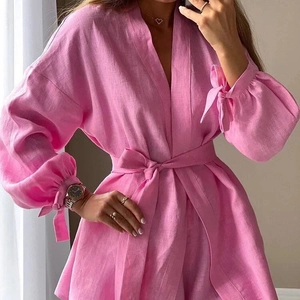 Détail du haut rose à manches longues avec taille lacée et nœuds décoratifs aux poignets