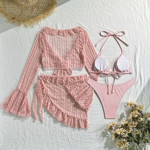 Flat lay of pink four-piece lace mesh bikini set with flared sleeves and ruffled skirt