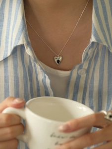 Close-up of S925 sterling silver heart necklace and matching ring with black enamel inlay