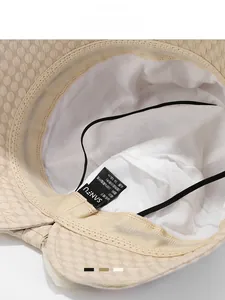 Detail view of beige sun hat interior with adjustable strap and textured fabric lining