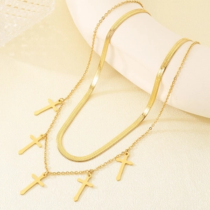 Detailed view of layered golden snake chain with five cross pendants on display