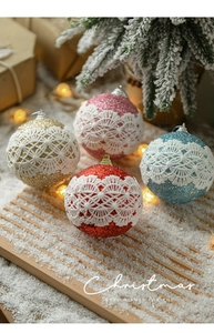 Detail of 8cm glitter Christmas balls with white lace trim on a festive snowy tray