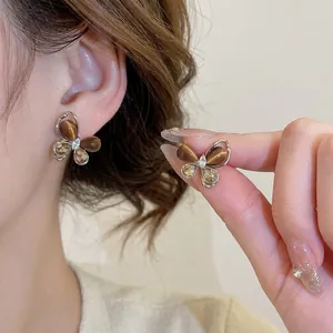 Boucles d'oreilles papillon vintage avec oeil de tigre et zircon portées par modèle