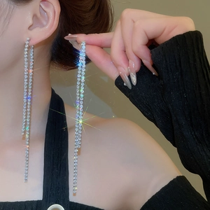 Detailed close-up of long silver tassel earrings with shimmering white cubic zirconia crystals