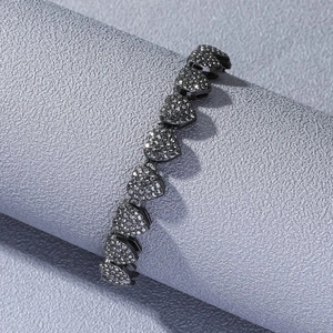 Detailed view of hip hop black iced-out heart link necklace with pave setting on grey surface