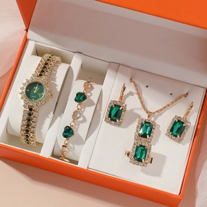 Luxury women's gold watch and jewelry set with green gemstones in a premium gift box