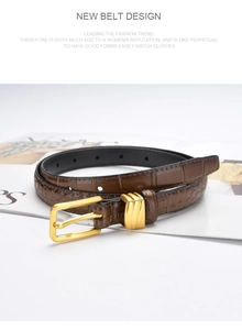 Detail of slim brown crocodile embossed leather belt with gold buckle and wavy loop
