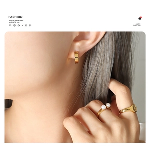 Detail of 18k gold-plated non-pierced clip earrings and pearl ring on model