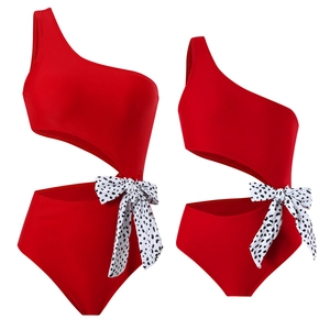 Detail of red one-shoulder cutout swimsuit with polka dot bow for mother and daughter