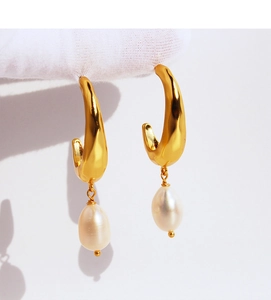 Close-up of French vintage hammered gold earrings with elegant natural drop pearls